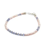 Delicate bracelet featuring 3 mm genuine tanzanite gemstones and peach freshwater pearls, accented with sterling silver spacers and clasp.