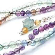 A stunning double-strand fluorite bracelet with a unique helix design, featuring faceted fluorite beads and a sterling silver clasp with a floral detail.