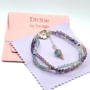 A stunning double-strand fluorite bracelet with a unique helix design, featuring faceted fluorite beads and a sterling silver clasp with a floral detail.