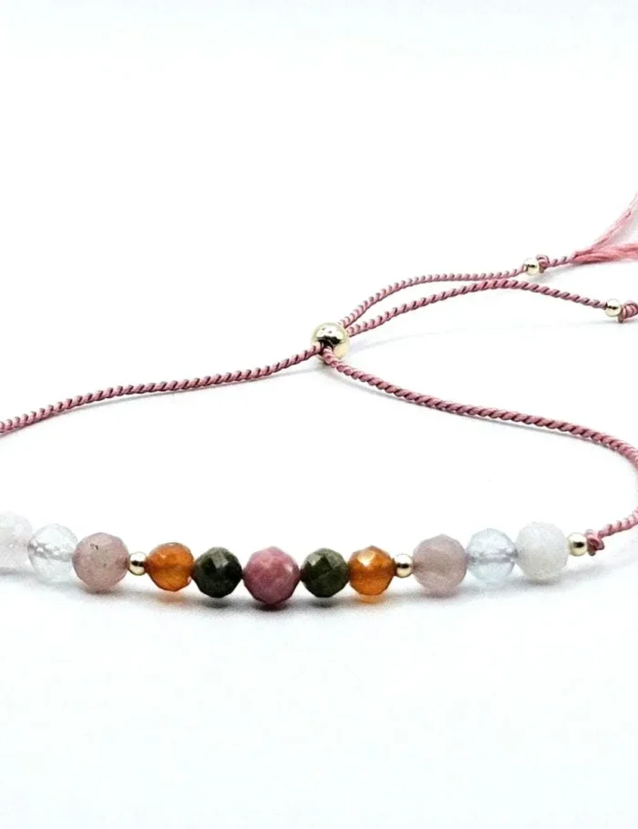 A nurturing fertility bracelet with moonstone, aquamarine, rhodonite, rose quartz, and unakite, accented with sterling silver on an adjustable pink silk cord. Designed to support fertility and emotional well-being.