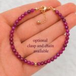 Red ruby bracelet in woman's palm, showing size comparative